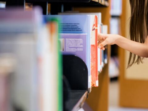Kleines_Mädchen_sucht_ein_Buch_in_der_Bibliothek