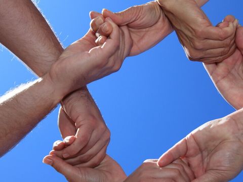 Hände mehrerer Menschen greifen ineinander