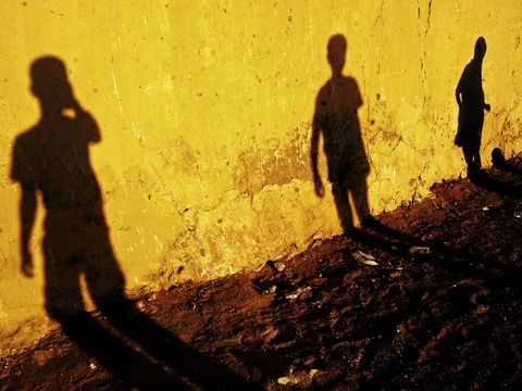 Schatten von Jugendlichen an Hauswand durch Sonnenlicht
