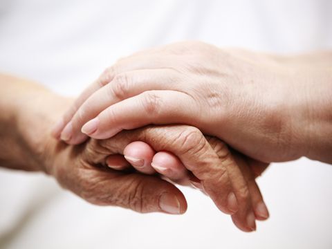 Alte und junge Hand fassen sich an