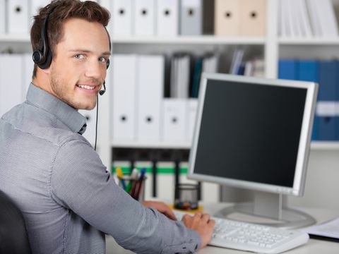 Mann mit Headset am PC