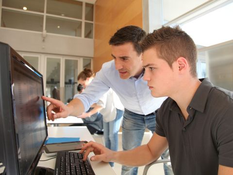 Ausbilder unterweist Auszubildenden am PC