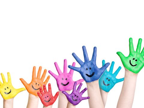 lachende Kinderhände in regenbogenfarben