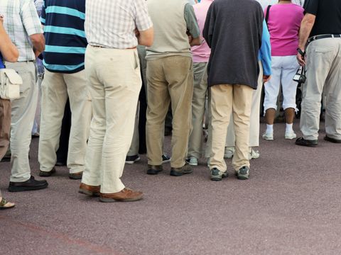 Mehrere Menschen verschiedenen Alters in einer Warteschlange