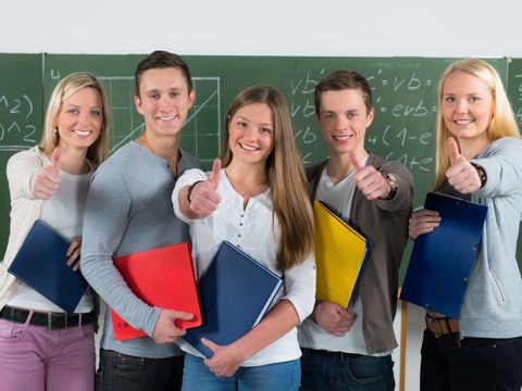 motivierte Schülergruppe zeigt Daumen hoch