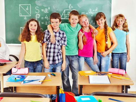 Schüler stehen in einer Reihe vor der Tafel