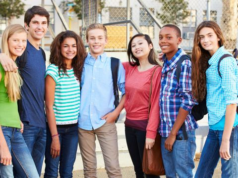 Gruppe von jugendlichen Menschen vor einem Klassenraum