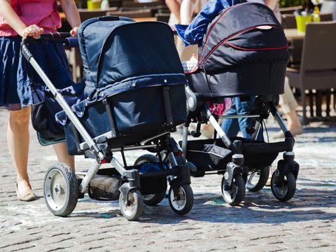 Fußgängerin mit Kinderwagen in der Stadt