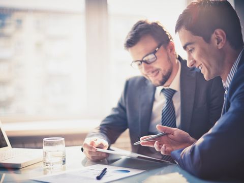 Zwei Männer besprechen ein Projekt am Schreibtisch