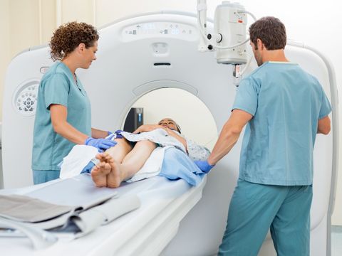 Pflegefachpersonen, die eine Patientin auf die Computertomografie vorbereiten