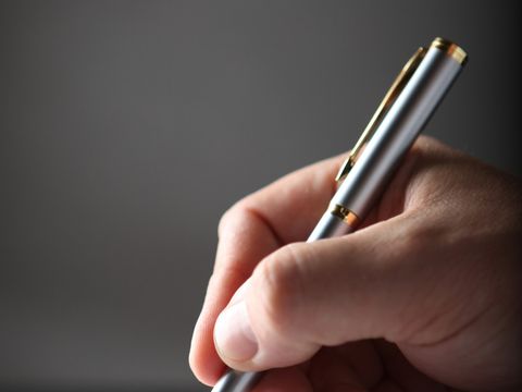 Hand mit Kugelschreiber unterschreibt Vertrag