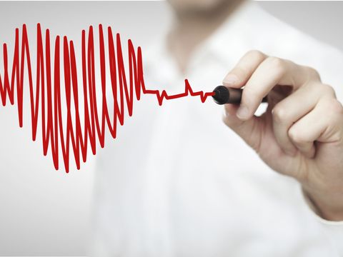 Mediziner malt ein Herz, das in ein EKG übergeht