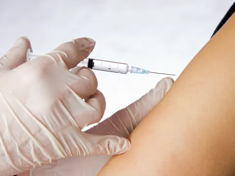 Mediziner verabreicht Spritze an einem Arm