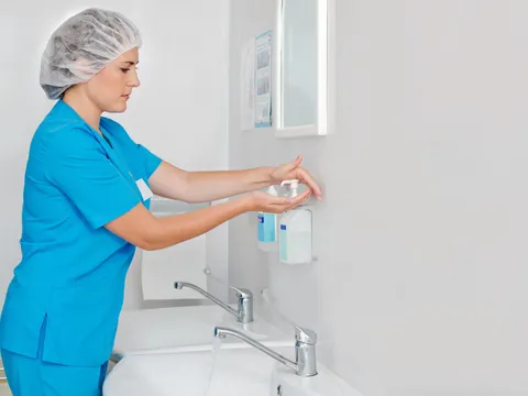 Medizinerin in einem Krankenhaus desinfiziert sich die Hände