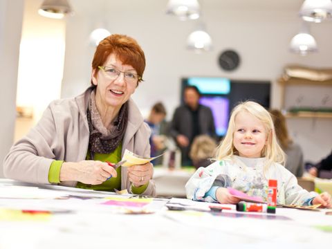 Seniorin und Kind basteln gemeinsam