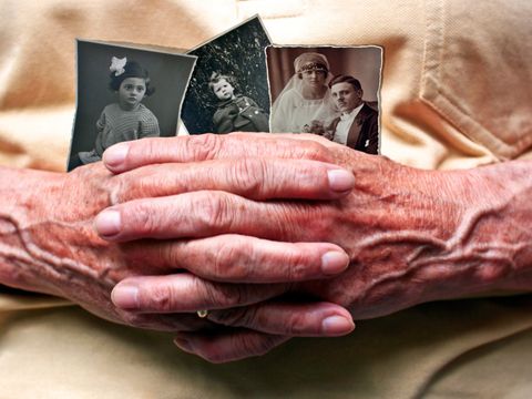 Bildausschnitt Seniorinnenhände halten vergilbte Erinnerungsfotos