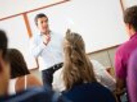 Lehrer steht vor den Schülern und erklärt