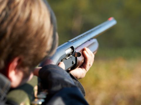 Eine Person zielt mit einem Gewehr