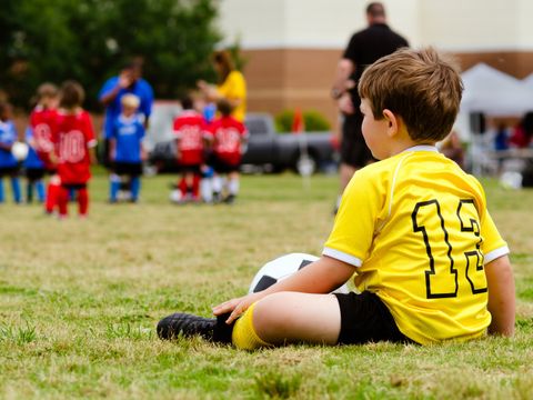 Kleiner Junge beobachtet ein Fußballspiel
