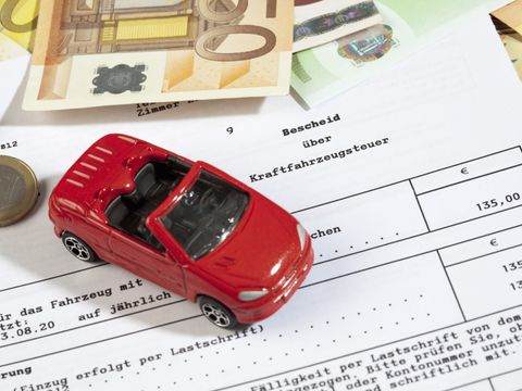 Spielzeugauto steht auf Kfz-Steuerbescheid