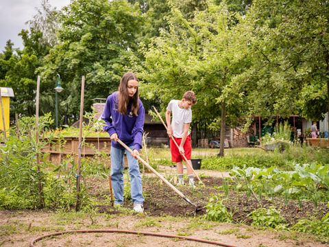 Zwei Jugendliche gärtnern im Schulgarten der Hagenbeck-Oberschule Weißensee