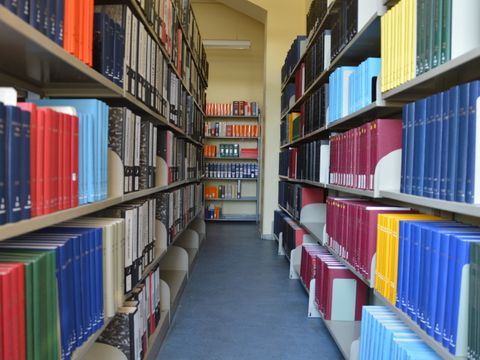 Gang zwischen Bücherregalen links und rechts mit vielen Büchern
