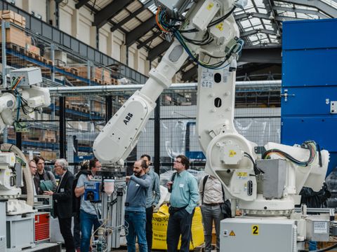 Eine große Halle mit einem übergroßen Roboterarm