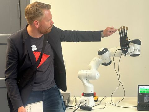 Ein junger Mann erklärt eine Roboterhand