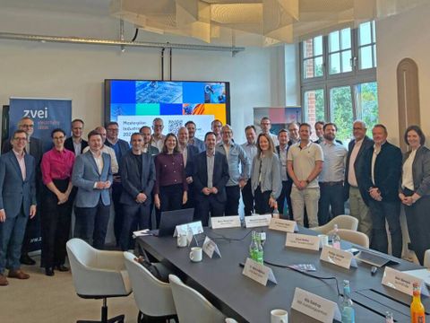 Eine Gruppe von Menschen in einem Konferenzraum zu einem Gruppenbild aufgestelt