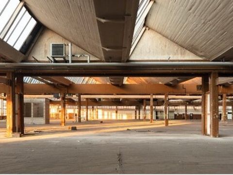 Weiter Blick durch eine lichtdruchflutete leere Lagerhalle