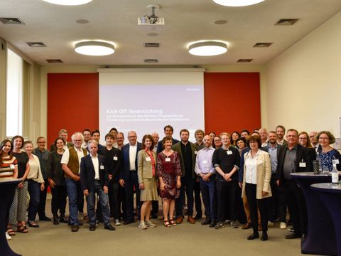 Gruppenbild vor roter Wand