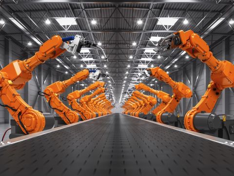 Orangene Robotorarme an einer Produktionsstrecke