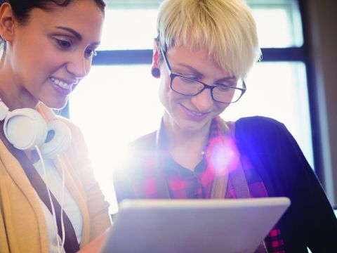 Zwei Frauen blicken auf einen Tabletcomputer