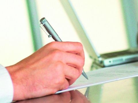 Eine Person unterschreibt ein Dokument