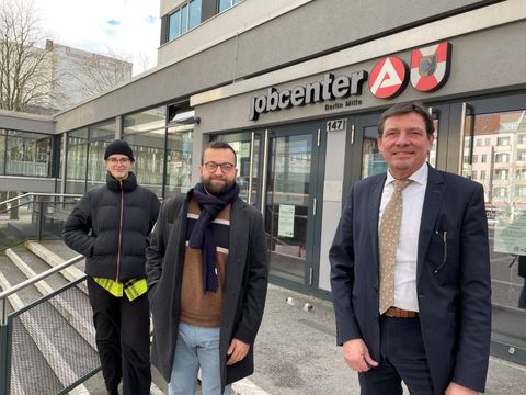 Die Abgeordneten Laura Neugebauer und Taylan Kurt mit Geschäftsführer Lutz Mania vor dem Jobcenter Berlin Mitte