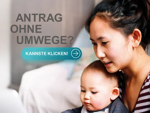 Eine Frau mit einem Baby auf dem Arm am PC