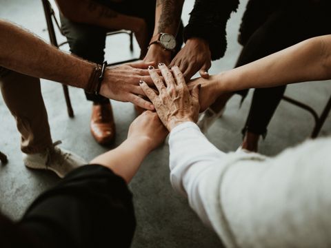 Group of diverse team joining hand in the middle