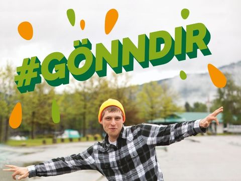 Ein junger Mann mit ausgestreckten Armen, der in die Kamera blickt. Darüber der Schriftzug Hashtag GönnDir
