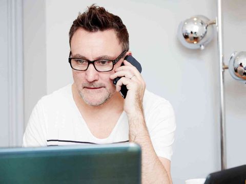 Computeruser telefoniert mit dem Helpdesk