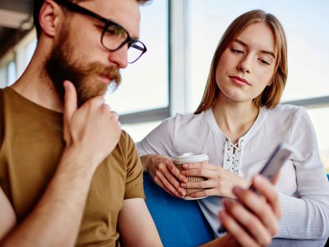 Ein Mann und eine Frau schauen auf sein Handy