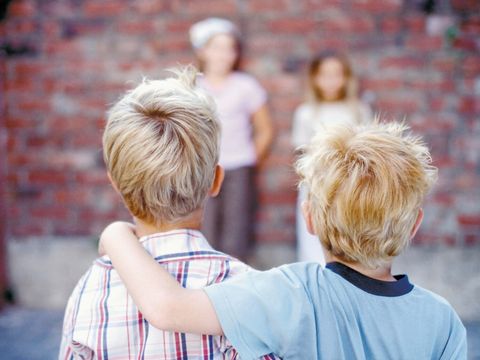 4 Kinder stehen an einer Mauer und spielen