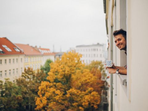 junger Mann schaut während der Kaffeepause aus dem Fenster