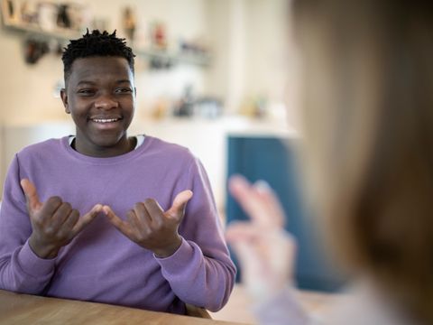 junger Mann unterhält sich in Gebärdensprache