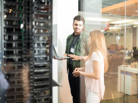 Eine Frau und ein Mann stehen in einem Serverraum