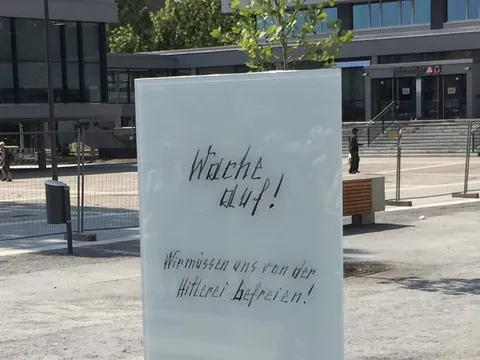 Glasstele mit Aufschrift "Wache auf! Wir müssen uns von der Hitlerei befreien!"