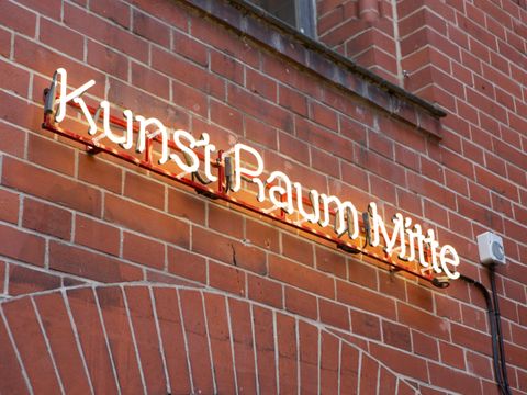 Neonschrift an Backsteinwand