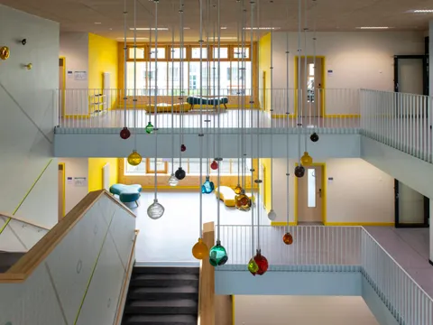 Bunte Glaskugeln hängen von der Decke eines Treppenhauses