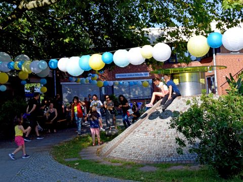 Kinder spielen im Innenhof des Gemeinschaftshauses während des Sommerfests zum 50jährigen Jubiläum.