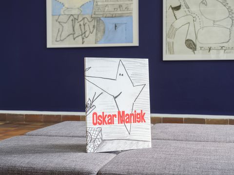Katalog zur Ausstellung „Oskar Manigk. Egmont-Schaefer-Preis für Zeichnung 2024“, im Hintergrund: Oskar Manigk, Unbedenkliches, 2009, Mischtechnik auf Bütten/ Es gibt keine Fehler!, 2009, Mischtechnik auf Bütten