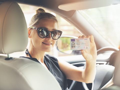 Frau hält Kartenführerschein in die Kamera